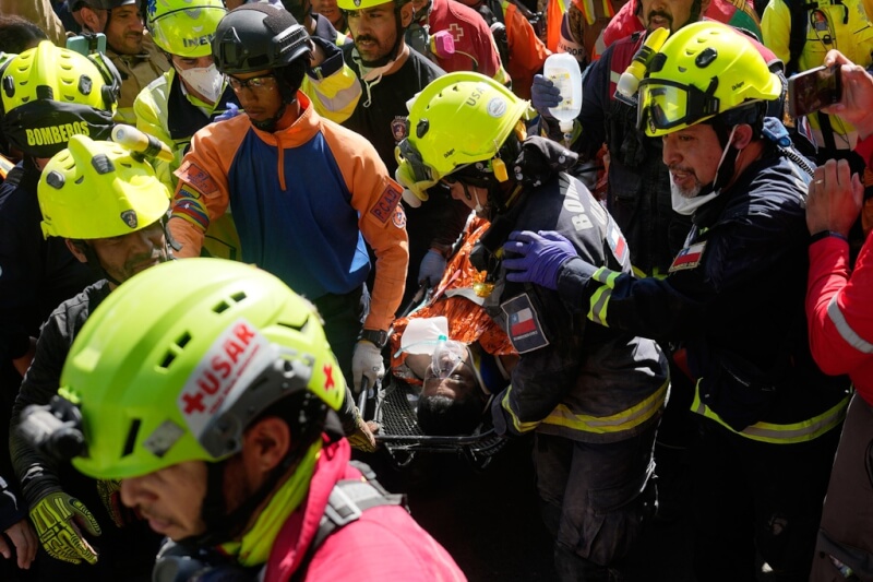 因委內瑞拉強震而受困瓦礫堆8天的警衛吉爾生還獲救，救援人員以擔架將他抬出。（美聯社）