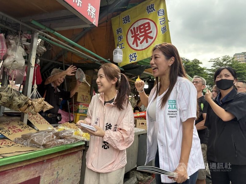 國民黨立委徐巧芯(前左)4日陪同民眾黨籍新北市議員參選人陳怡君(前右)赴中和區和平街黃昏市場拜票,與攤商互動熱絡。中央社記者曹亞沿攝 115年7月4日