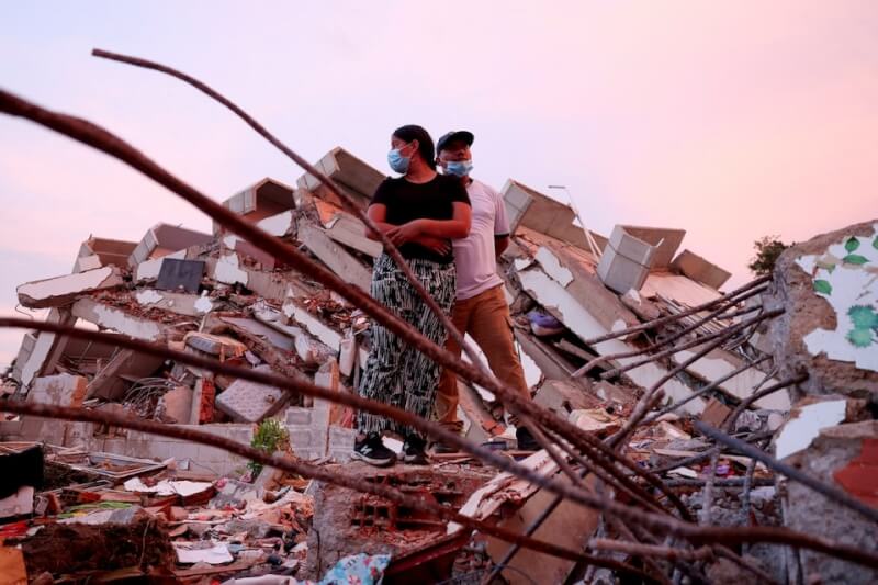 委內瑞拉地震災民站在倒塌的建築物上,持續等待救援團隊的消息。(路透社)