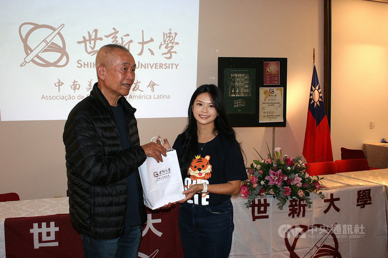 中南美洲世新校友會4日於聖保羅華僑文教服務中心舉行成立茶會,會長謝如欣代表世新董事長周成虎致贈禮品予校友吳治成。中央社記者唐雅陵聖保羅攝 115年7月5日