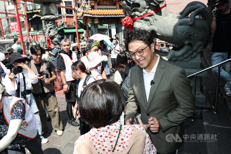 民進黨台北市長參選人沈伯洋（右）5日上午到士林慈諴宮參拜，與民眾互動並合影留念。中央社記者吳家昇攝　115年7月5日