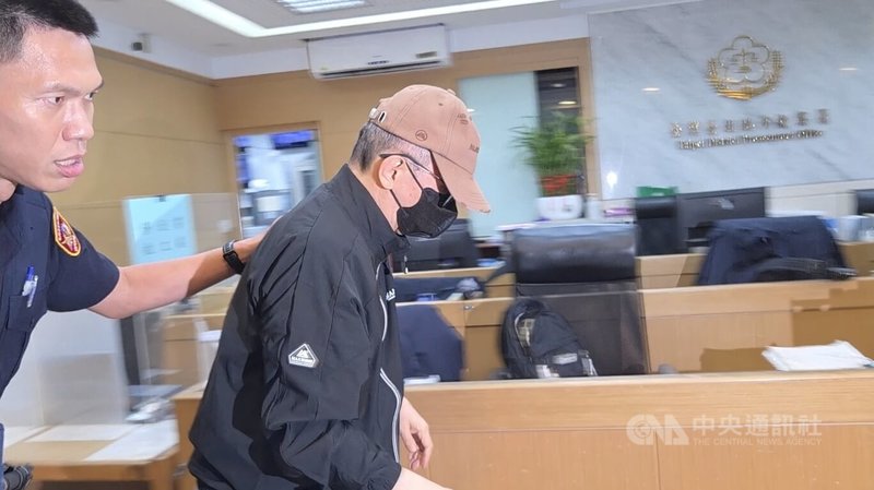 長榮集團創辦人張榮發三子張國政(中)遭控涉及內線交易,6日他戴著帽子、口罩至台北地檢署複訊,低頭不語。中央社記者謝君臨攝 115年7月6日