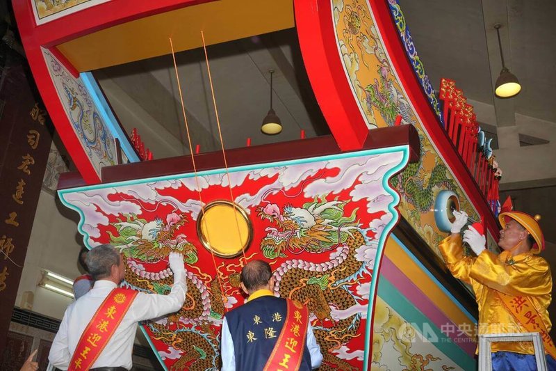 東港東隆宮丁未正科大總理洪景崇(右)、屏東縣議長周典論(左)等人,8日依循古禮為王船龍目、船身等重要部位點上象徵平安、驅邪與護佑的硃砂。中央社記者黃郁菁攝 115年7月8日