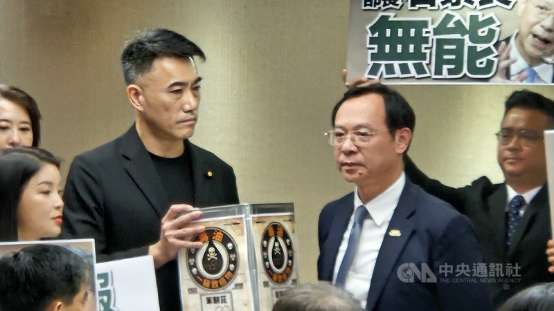 立法院社福與衛環委員會8日邀請衛生福利部長石崇良等就食安問題進行專題報告，質詢開始前國民黨立委林沛祥（左2）更現場贈送一個寫有「毒油、一級致癌物苯駢芘」的油桶給石崇良（右2）。中央社記者曾以寧攝 115年7月8日