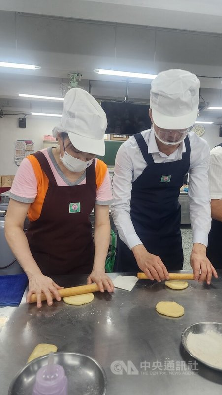 高雄女監受刑人57歲阿萍(左)5月考過烘焙麵包丙級檢定,成為女監中檢定最高齡過關受刑人。高雄地檢署檢察長黃元冠(右)8日前往鼓勵,並體驗製作太陽餅。中央社記者洪學廣攝 115年7月8日