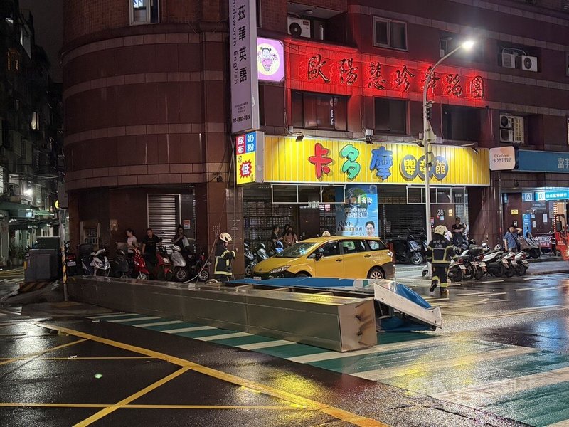 新北三重區一間銀行大型招牌10日晚間掉落人行道,警方獲報後立即趕抵現場交通管制,並通報消防局協助處理。(翻攝畫面)中央社記者曹亞沿傳真 115年7月10日