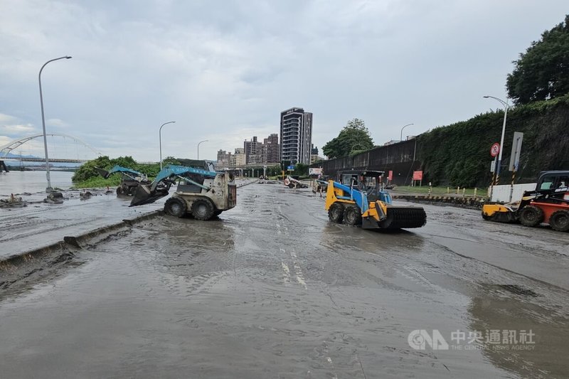 颱風巴威挾帶豪大雨及上游水庫洩洪，造成堤外多處道路淹沒及泥土淤積，新北市府12日凌晨動員大量機具及人力，進行道路清淤及復原。中央社記者王鴻國攝　115年7月12日