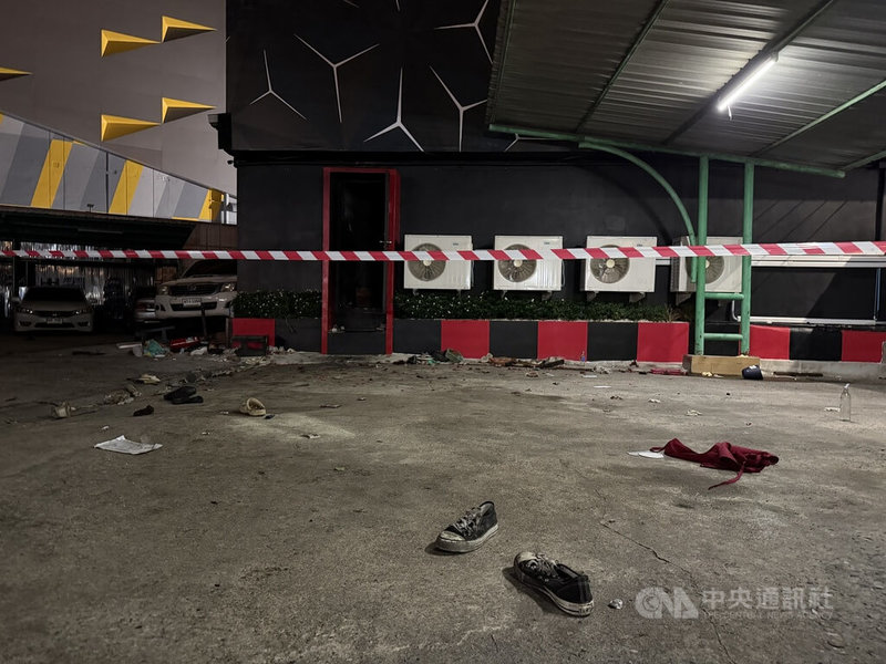 泰國曼谷啤酒餐廳發生火災後,現場已拉起封鎖線,等待鑑識人員進一步調查起火原因。圖為酒吧後門外仍散落鞋子及其他物品。中央社記者李宗憲曼谷攝 115年7月13日