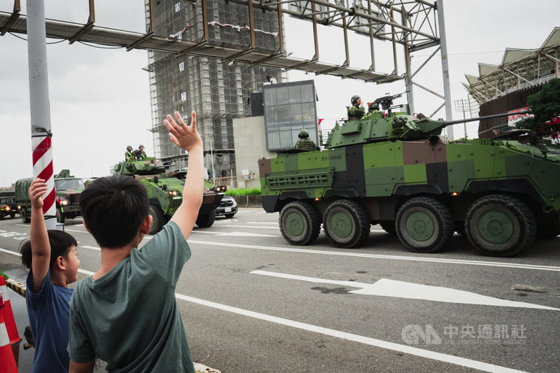國軍聯合防禦操演13日實施,圖為孩童在桃園青埔一帶向正在機動的雲豹八輪甲車打招呼、打氣。中央社記者游凱翔攝 115年7月13日