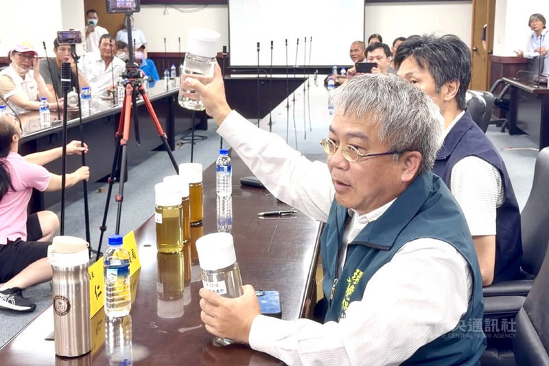 台南市養殖團體與民代13日在議會召開記者會，指稱城西掩埋場疑似汙水外洩，市府環保局長許仁澤（前右）出示經過處理的掩埋場放流水澄清。中央社記者楊思瑞攝　115年7月13日