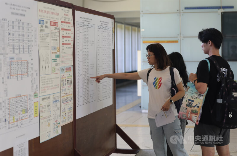 115學年度分科測驗14日持續進行，第2天考科為歷史、地理、數學乙、公民與社會，有家長帶著考生在公告欄前確認考場資訊。中央社記者趙世勳攝　115年7月14日
