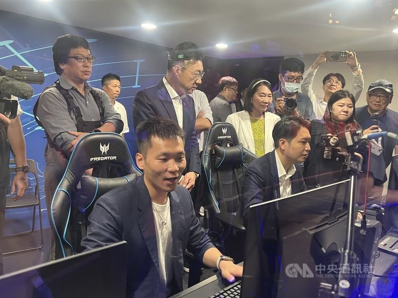 立法院教育及文化委員會15日到台中市弘光科技大學考察電競場館設施,運動部長李洋(前左)、國民黨立委羅廷瑋(前左2)小試身手,兩人下場PK電競,立法院副院長江啟臣(中排左2)也在兩人身後觀戰。中央社記者郝雪卿攝 115年7月15日
