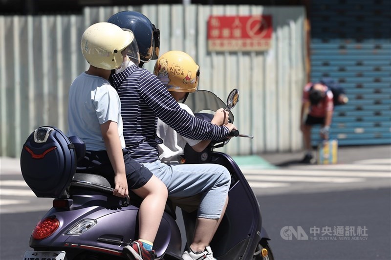 圖為新北市蘆洲區家長以機車接送孩童。（中央社檔案照片）