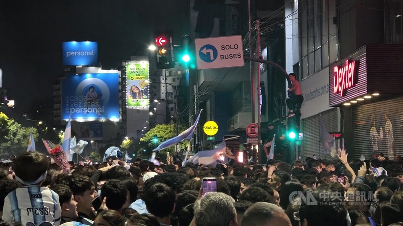 阿根廷挺進2026年世界盃決賽後，布宜諾斯艾利斯有球迷攀上交通號誌、路燈及街邊鐵皮屋頂揮舞國旗，高聲歡呼慶祝球隊晉級。中央社記者黃韻如布宜諾斯艾利斯攝　115年7月16日