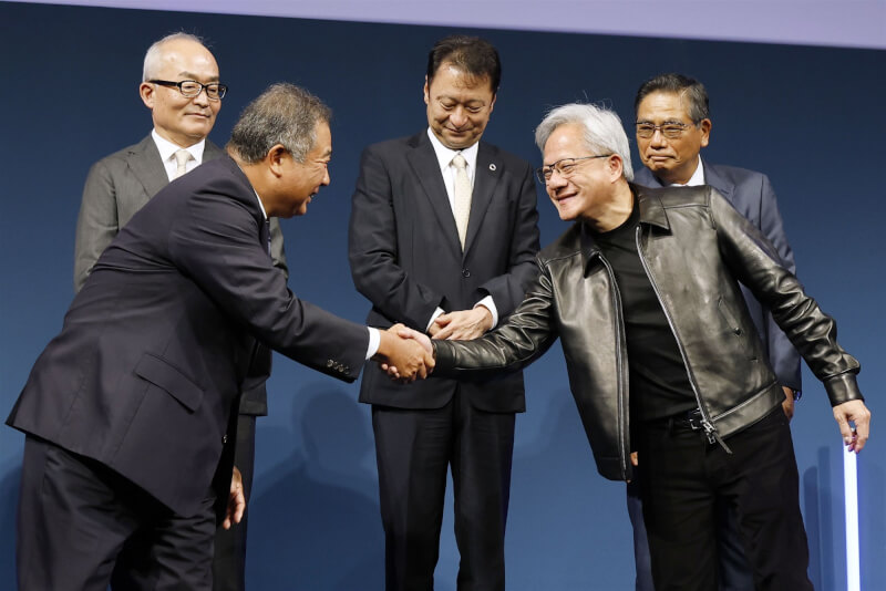 日本AI開發公司Noetra 16日正式啟動，社長丹波廣寅（前左）和輝達執行長黃仁勳（前右）握手。（共同社）