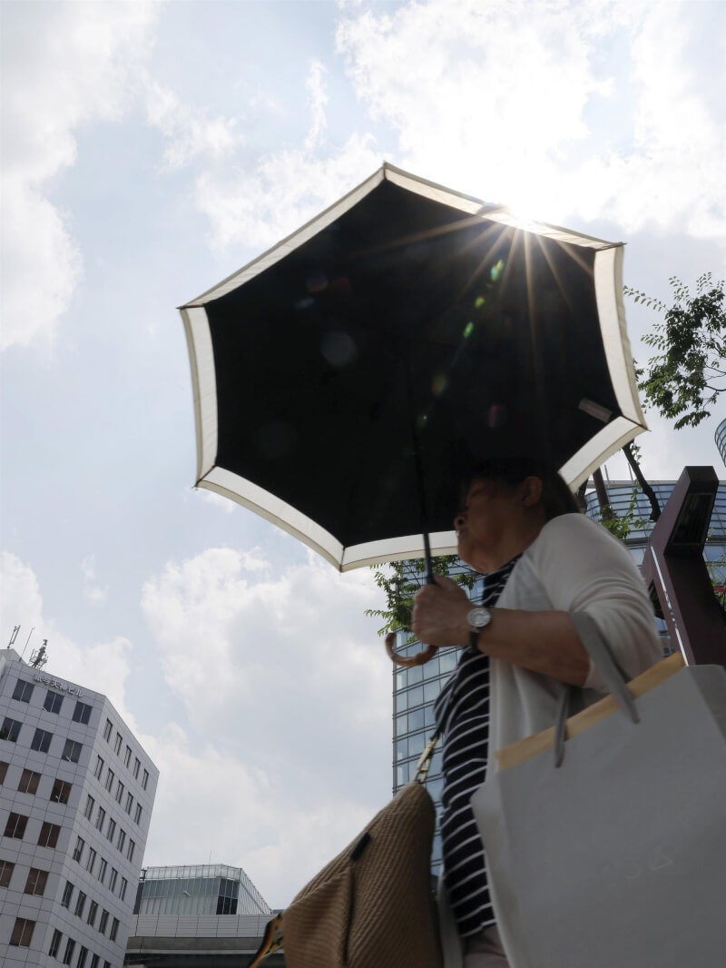 日本關東及東北17日大氣狀況極不穩定，多地出現局部強降雨。北海道至九州則普遍出現高溫天氣，北海道罕見迎來35度以上「猛暑日」。圖為福岡市居民在豔陽下撐傘嚴防中暑。（共同社）