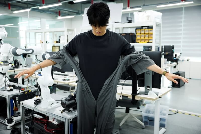 研究員示範自動穿衣機器人技術。(路透社)