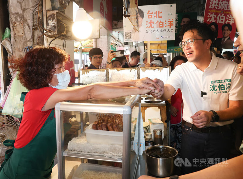 民進黨台北市長參選人沈伯洋(右)18日上午前往直興市場拜票,沿途向攤商和民眾致意,尋求支持。中央社記者謝佳璋攝 115年7月18日