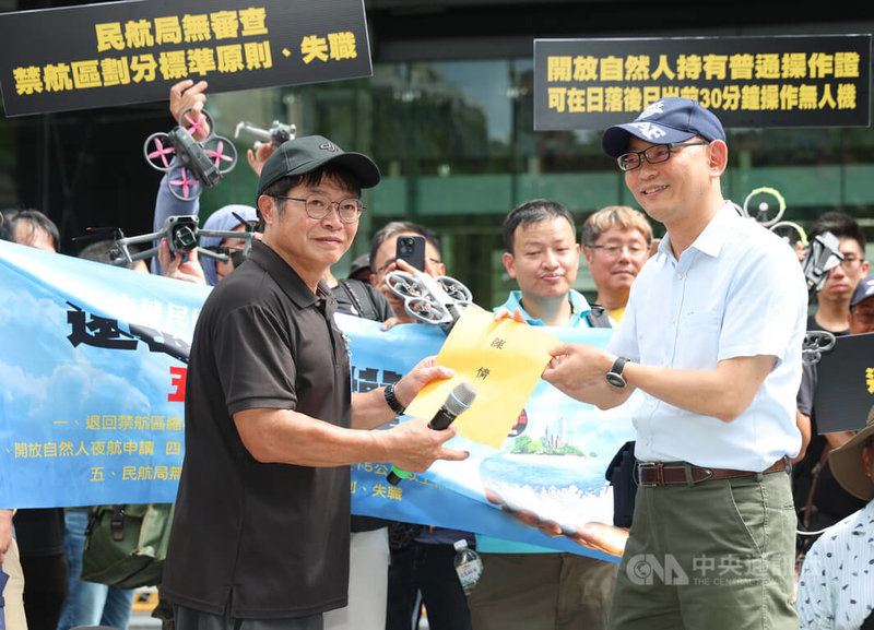 多名無人機玩家18日到交通部外抗議最新公布的無人機禁航範圍,恐影響現有飛行訓練及考照使用。313反不平等空域聯盟發起人吳明陽(前左)並遞交陳情書給民航局無人機辦公室執行秘書耿驊(前右)。中央社記者張新偉攝 115年7月18日