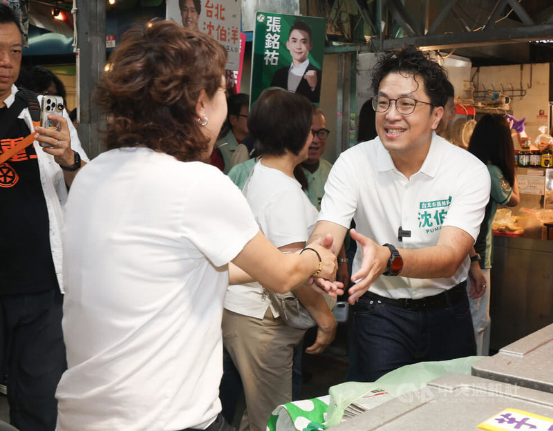 民進黨台北市長參選人沈伯洋（右）18日上午前往直興市場拜票，近距離和攤商及民眾互動，爭取支持。中央社記者謝佳璋攝 115年7月18日