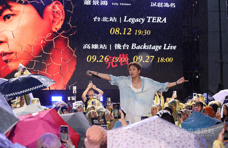 中央氣象署發布豪雨特報,對流雲系發展旺盛,易有短延時強降雨。發行首張個人專輯「蕭景鴻Edy Hsiao」的歌手、演員蕭景鴻(圖),16日在台北市信義香堤廣場舉辦簽唱會,在雨中演唱歌曲,歌迷撐傘、穿雨衣不離不棄在原地聽歌力挺。中央社記者張新偉攝 115年7月16日
