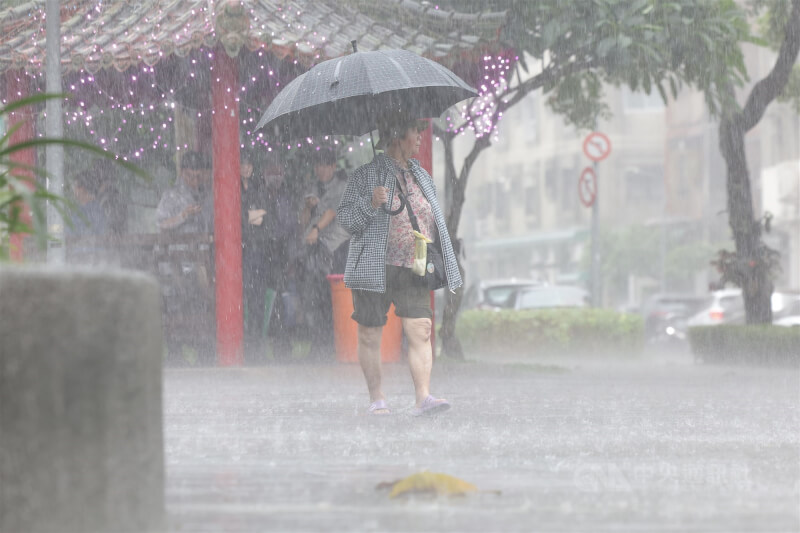 圖為台北市大安區出現午後雷陣雨，民眾撐傘擋雨。（中央社檔案照片）