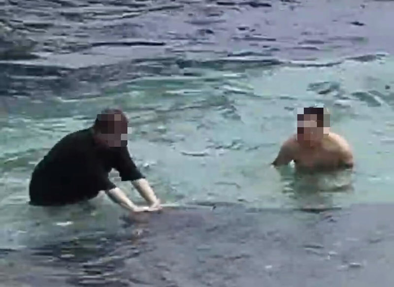 2名遊客在小琉球花瓶岩岸際觸摸海龜，其中1名男子雙手撫摸海龜背部，海龜向前游離後，另1名男子也伸手觸摸海龜數秒，觸摸事實明確，依違依野生動物保育法函送屏東地檢署偵辦。（海巡署南部分署第五岸巡隊提供）中央社記者黃郁菁傳真　115年7月20日