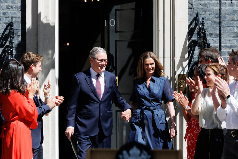 英國首相施凱爾(左)20日最後一次以首相身分步出唐寧街10號官邸,妻子維多利亞(右)伴隨,一同接受提早聚集在門外的支持者、執政團隊與公務體系成員鼓掌歡呼。(英國首相府提供)中央社記者陳韻聿傳真 115年7月20日