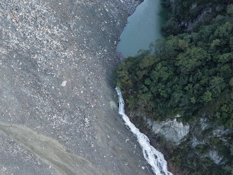 林保署花蓮分署22日清晨以無人機空拍萬里溪堰塞湖，確認已溢流，因堰塞湖壩體目視多岩石、粗礫，目前溢流水量尚不足以大規模沖蝕下切壩體，影響初估仍侷限於河道內。（林業及自然保育署花蓮分署提供）中央社記者李先鳳傳真　115年7月22日