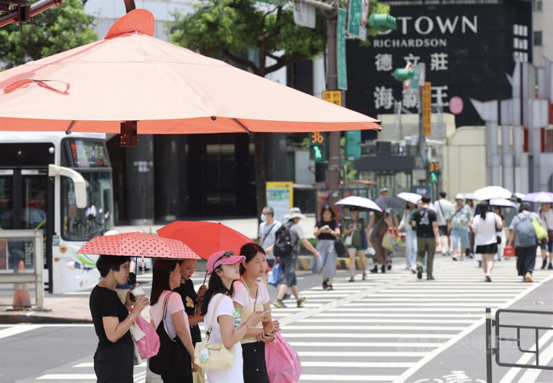 圖為民眾於台北市西門町遮陽傘下避暑。（中央社檔案照片）
