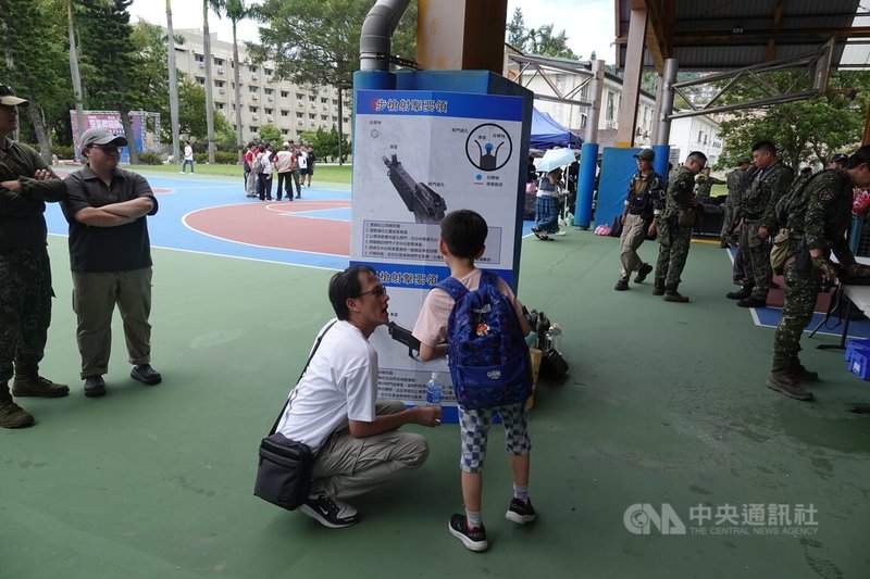 國防部25日舉辦「2026全國空氣軟槍競技射擊比賽-北區初賽」,1名成年男性正在和同行的孩童,解釋射擊要領。中央社記者吳書緯攝 115年7月25日