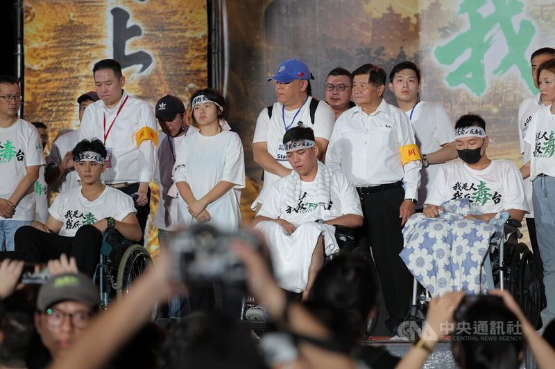國民黨「我是人,我反毒台」集會25日在凱達格蘭大道登場,近期響應絕食抗議的賴苡任(前中)、楊植斗(前右)、張家馨(前左)一同上台向民眾致意。中央社記者翁睿坤攝 115年7月25日