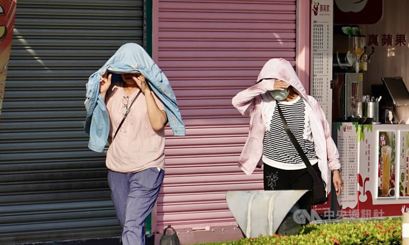 圖為高雄地區午後陽光刺眼，駁二藝術特區周邊民眾以手、衣物遮擋炙熱日光。（中央社檔案照片）