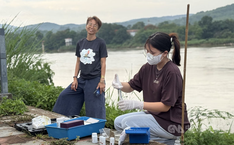泰國高中生志工詩麗瑪妮(右)在湄公河支流岸邊採集水樣並進行檢測,希望了解重金屬污染對河川及漁業的影響。她表示,投入環保倡議是為了守護以捕魚維生的父親及家鄉文化。中央社記者李宗憲清萊攝 115年7月30日