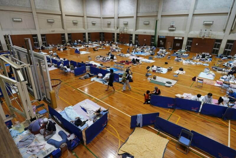 日本熊本縣遭遇最大震度7級強烈地震，八代市一處體育館成為避難中心，30日許多民眾在館內打地鋪休息。（共同社）