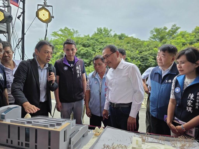新北市府推動興建八里第2座納骨塔，31日舉行破土典禮，市長侯友宜（右3）出席，並聽取建築師解說建物模型。（新北市工務局提供）中央社記者曹亞沿傳真　115年7月31日