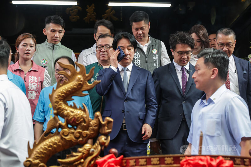中央氣象署31日發布高溫資訊,中午前後台北市為橙色燈號,總統賴清德(前中)上午穿著西裝至台北崁頂永義宮參香祈福,席間拿出手帕擦汗。中央社記者裴禛攝 115年7月31日