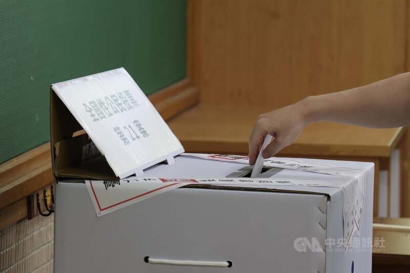 圖為民眾將公投票投入票匭。（中央社檔案照片）