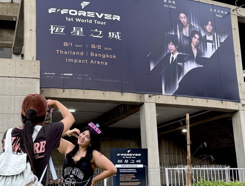 台灣男團F4成員言承旭、周渝民、吳建豪與五月天主唱阿信1日起一連兩天在泰國曼谷舉行演唱會，歌迷在場外大型看板前拍照留念。中央社記者李宗憲曼谷攝　115年8月1日