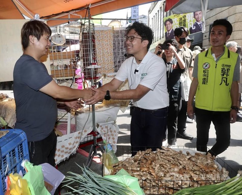 民進黨台北市長參選人沈伯洋（前中）1日前往中崙市場掃街拜票，沈伯洋與攤商握手致意，尋求選民支持。中央社記者張皓安攝 115年8月1日