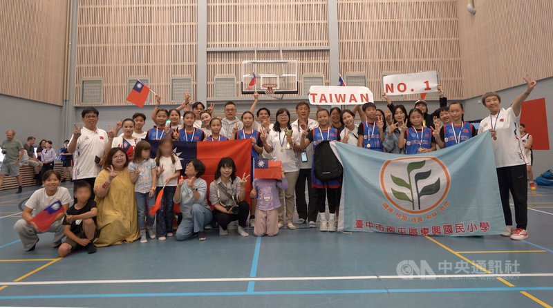 台中市東興國小女子籃球隊在芬蘭舉行的第39屆Delfin Basket國際籃球錦標賽奪冠,校長謝秀娟(中,持獎盃)、帶隊教練胡佳昕(右一)與全體隊員、台僑、家長在體育館合影留念。中央社記者巫祈麟坦培里攝 115年8月3日