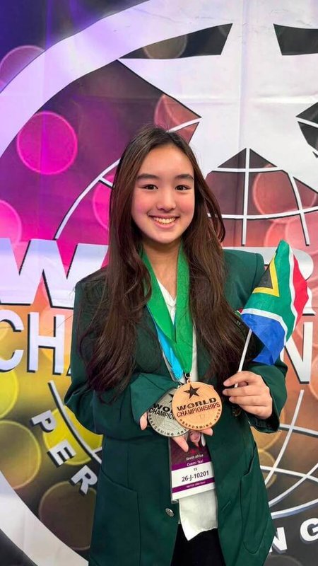 15歲南非台裔少女蔡穎兒代表南非參加2026年世界表演藝術錦標賽,晉級準決賽,並在世界音樂及聲樂自彈自唱項目分別獲得銀牌、銅牌。圖為她7月22日在美國拉斯維加斯手持獎牌及南非國旗留影。(蔡穎兒父親蔡澤秀提供) 中央社記者李依璇傳真 115年8月3日