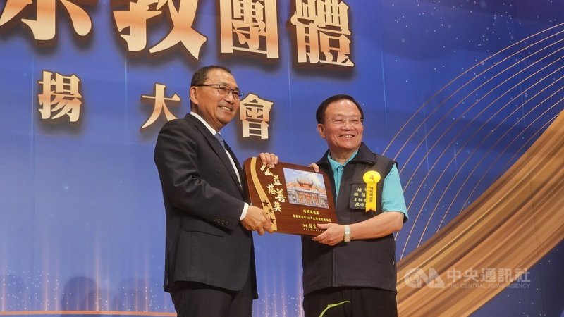 新北市政府4日舉辦績優宗教團體表揚大會,市長侯友宜(左)出席頒獎並感謝各宗教團體的公益捐助及社會教化貢獻,板橋埔墘福德宮主委廖榮清(右)上台領獎。中央社記者王鴻國攝 115年8月4日