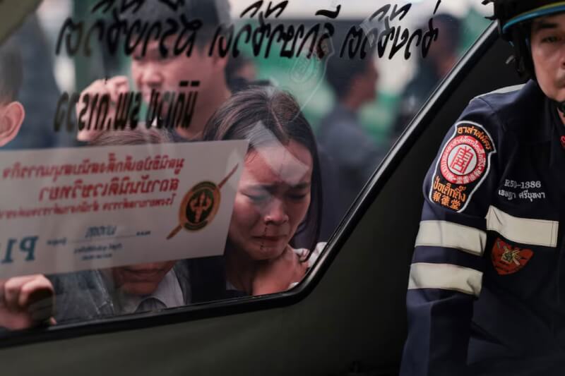 泰國曼谷近郊一所中學7日上午發生槍擊案，圖為罹難者家屬透過救護車車窗，看著罹難者遺體時神情哀戚。（路透社）