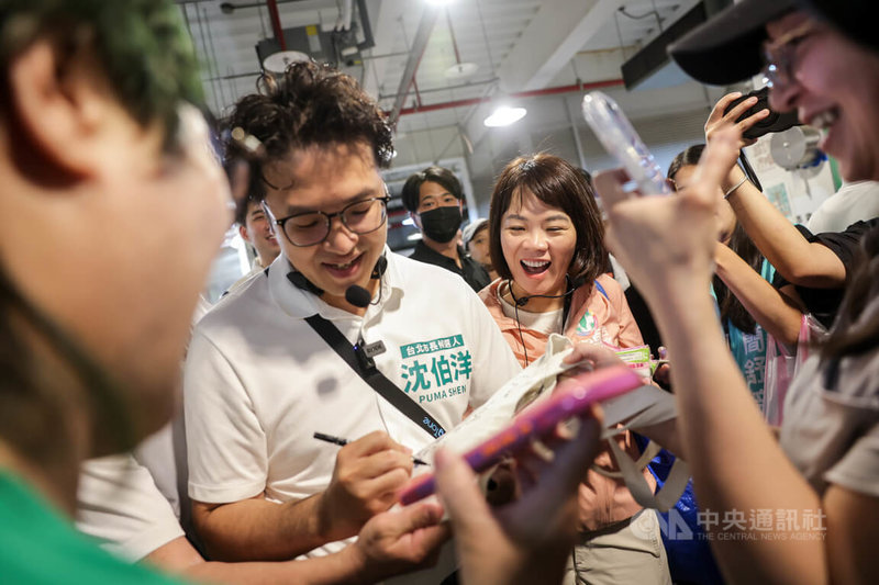 民進黨台北市長參選人沈伯洋（前左）8日上午赴成功市場掃街拜票，民眾熱情向沈伯洋索取簽名。中央社記者裴禛攝 115年8月8日