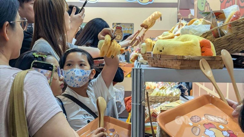 2026台灣文博會品牌商展8日起開放一般民眾入場，參展文創IP各自發揮創意妝點展區，其中「Crazyeyes瘋狂眼珠」將攤位打造為麵包鋪，民眾手拿托盤與麵包夾選取商品。中央社記者王寶兒攝　115年8月8日