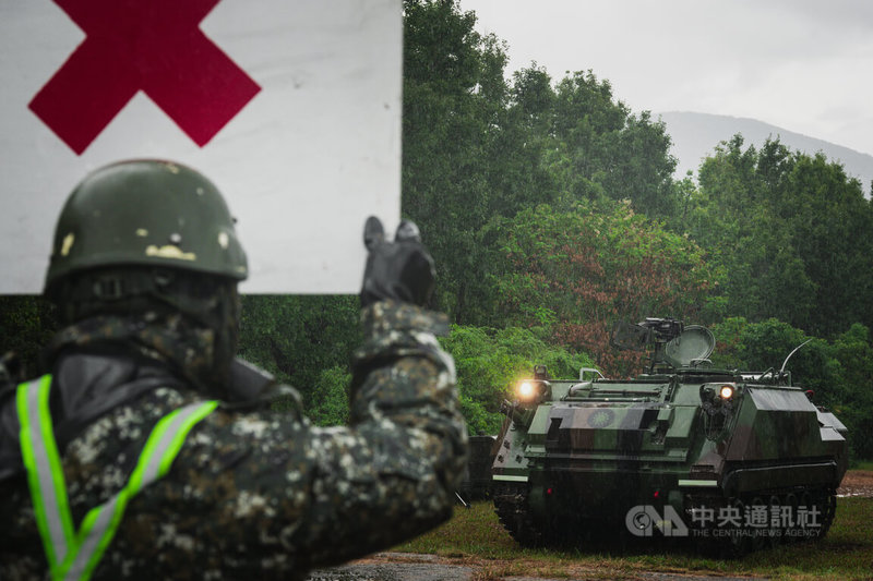 漢光42號實兵演習9日進入第5天，化學兵群對戰甲車除污，必須經過7道程序。圖為官兵舉牌提醒駕駛可向前至下一道除污程序。中央社記者游凱翔攝　115年8月9日