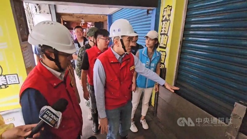 颱風白海豚逼近，基隆市區8日因海水倒灌，造成愛四路數十公尺路段積水，水量灌入商家，使得生財器具及貨物泡水。市長謝國樑（前右）9日前往會勘時積水已退去，有商家在門口架設擋水板。中央社記者王朝鈺攝　115年8月9日