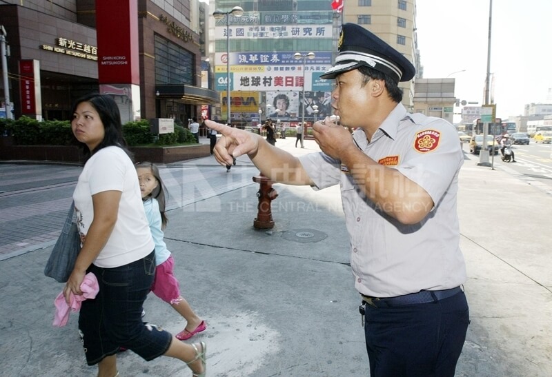 2005年9月9日北部地區實施萬安演習，警報發布後，台北市員警將行人趕進建築物內，淨空街道。（中央社檔案照片）