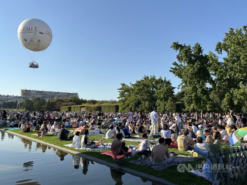 許多巴黎人12日晚間聚集在安德瑞・雪鐵龍公園觀賞日偏食。人們在草地上鋪墊子，一邊野餐，一邊等待食甚。中央社記者曾依璇巴黎攝　115年8月13日